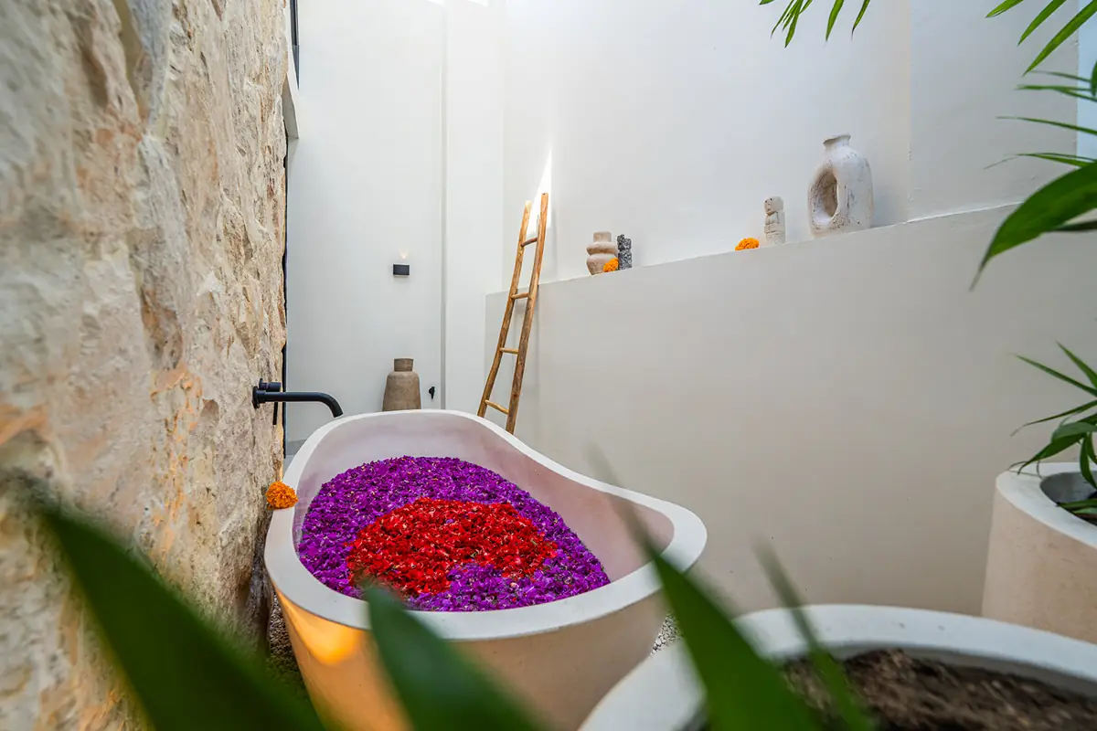 Stone bath prepared with flowers for a private villa ritual